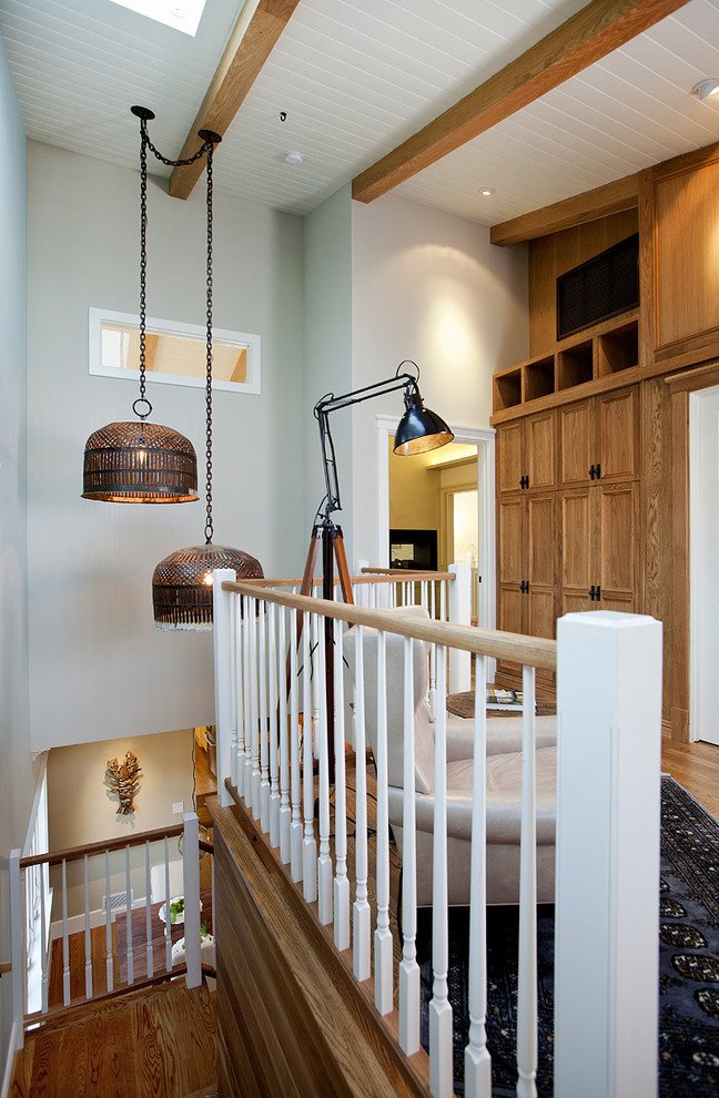 Imagen de sala de estar tipo loft actual pequeña sin chimenea con paredes azules, suelo de madera en tonos medios, televisor colgado en la pared y suelo marrón