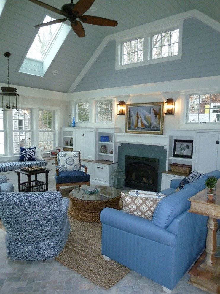 Foto de sala de estar abierta marinera grande con paredes azules, suelo de ladrillo, todas las chimeneas y marco de chimenea de piedra