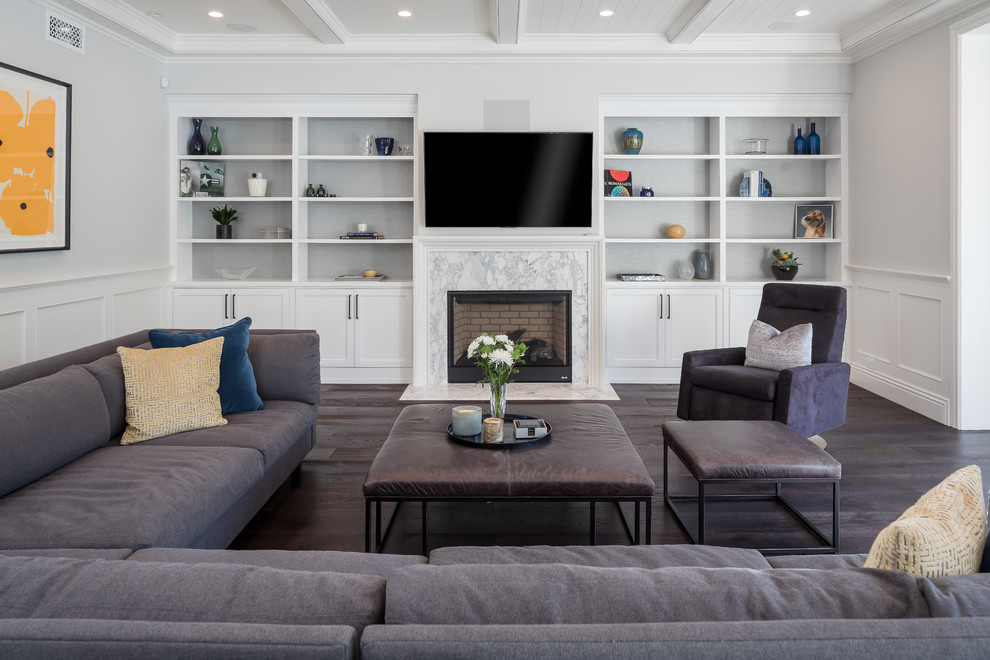 Maritimes Wohnzimmer mit weißer Wandfarbe, dunklem Holzboden, Kamin, Kaminumrandung aus Stein, TV-Wand und braunem Boden in Los Angeles