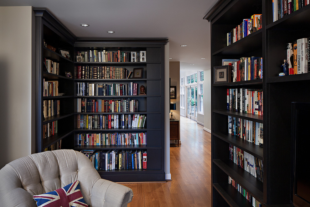 Esempio di un piccolo soggiorno chic chiuso con libreria, pareti grigie, pavimento in legno massello medio, nessun camino e parete attrezzata