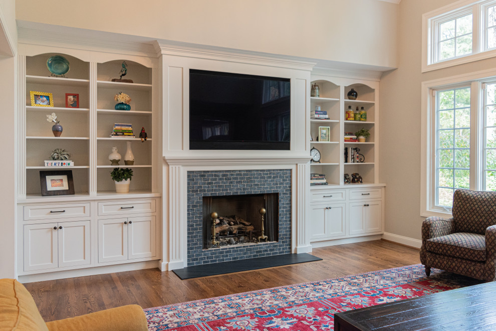 Inspiration for a large traditional open plan games room in Philadelphia with beige walls, medium hardwood flooring, a standard fireplace, a brick fireplace surround, a wall mounted tv and brown floors.