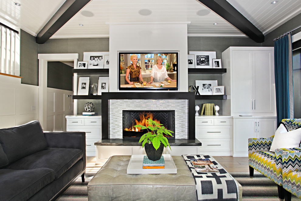 Стильный дизайн: гостиная комната в современном стиле с серыми стенами, стандартным камином, фасадом камина из плитки и телевизором на стене - последний тренд