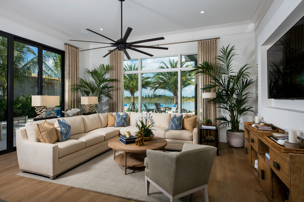 Imagen de sala de estar marinera sin chimenea con paredes blancas, suelo de madera en tonos medios, pared multimedia y alfombra