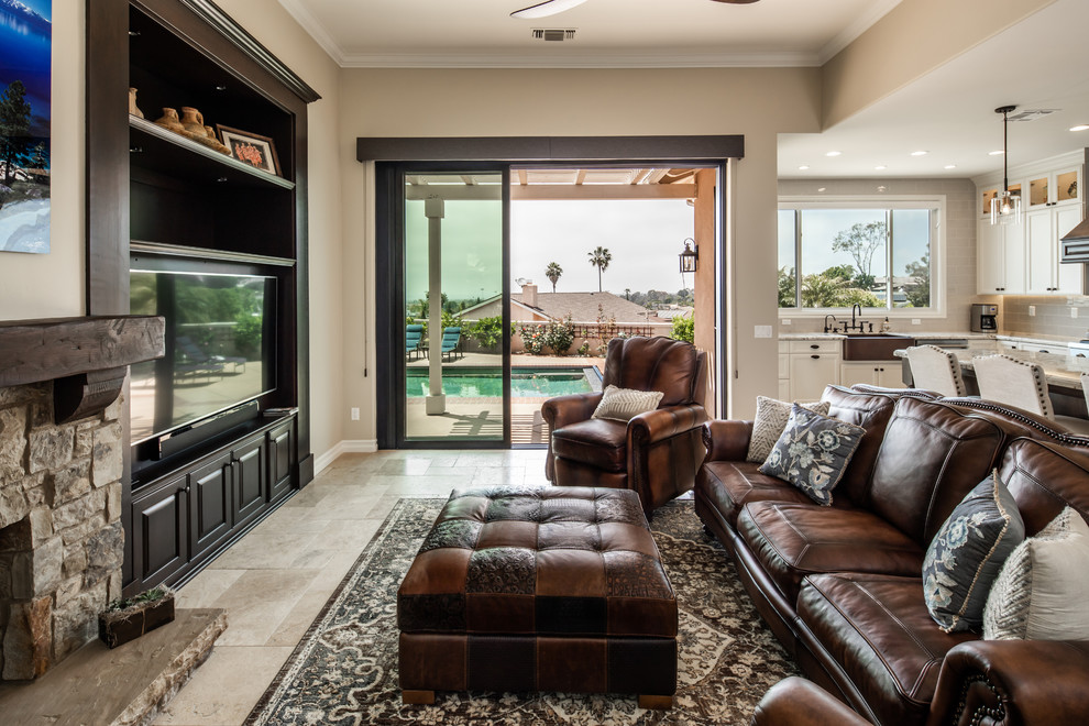 Inspiration for a large classic open plan games room in San Diego with beige walls, travertine flooring, a standard fireplace, a stone fireplace surround, a built-in media unit and beige floors.
