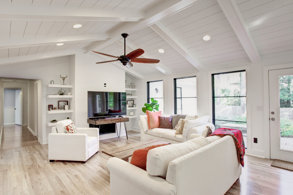 Exemple d'une salle de séjour nature de taille moyenne et ouverte avec un mur blanc, parquet clair, une cheminée ribbon, un manteau de cheminée en plâtre, un téléviseur indépendant et un sol marron.