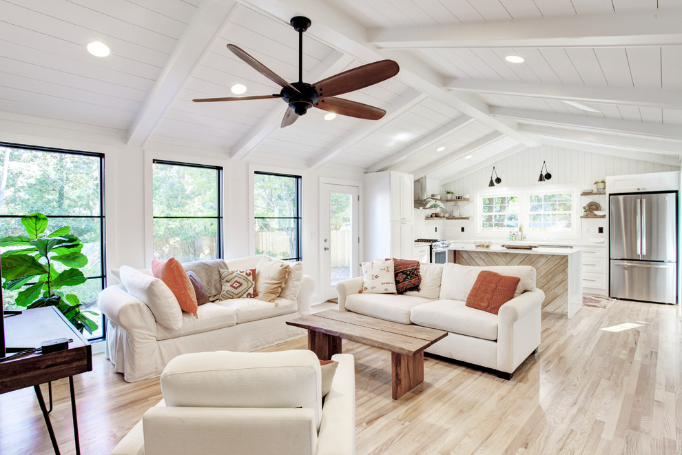 Inspiration for a mid-sized transitional open concept light wood floor and brown floor family room remodel in Atlanta with white walls, no fireplace, a plaster fireplace and no tv