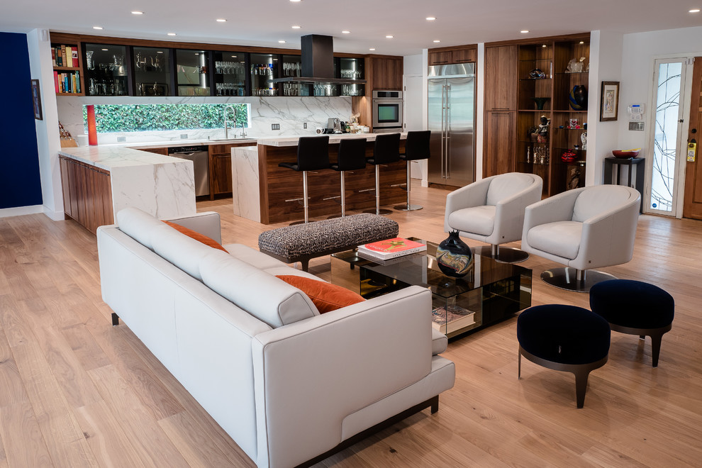 Example of a large minimalist open concept light wood floor and beige floor family room design in Los Angeles with a bar, white walls, a hanging fireplace, a stone fireplace and a wall-mounted tv