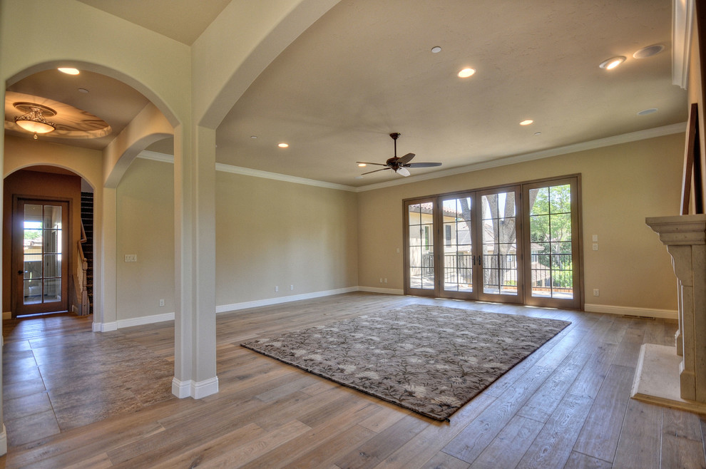 This is an example of a mediterranean open plan games room in Other with brown walls and medium hardwood flooring.