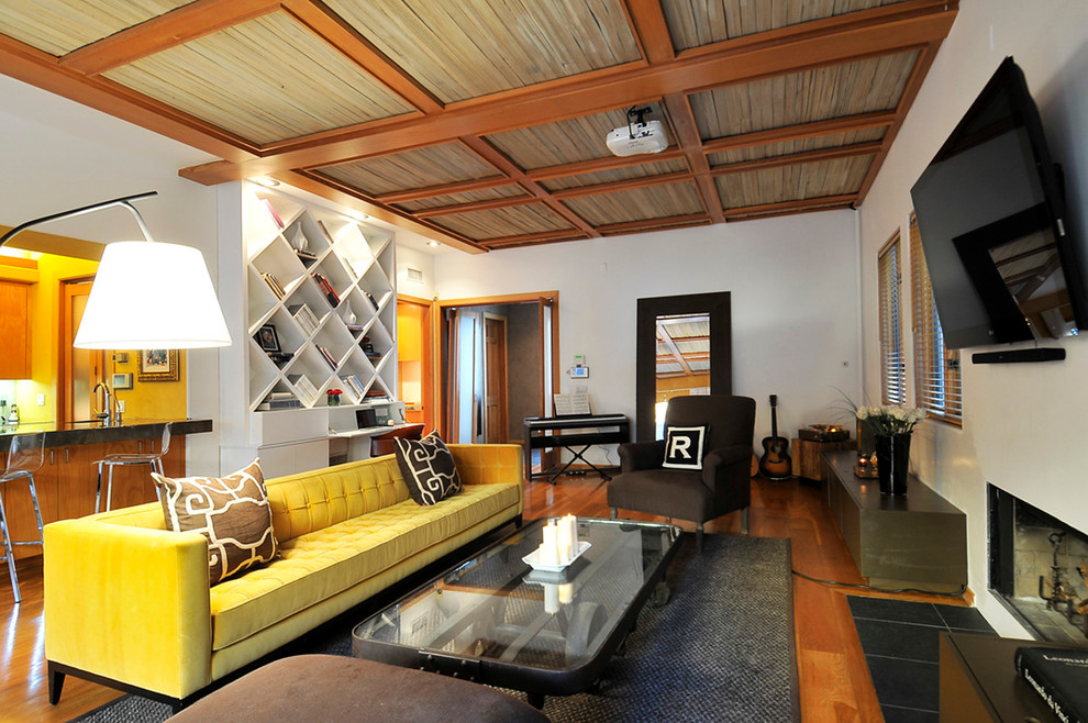 Ejemplo de sala de estar abierta actual con paredes blancas, suelo de madera en tonos medios y televisor colgado en la pared