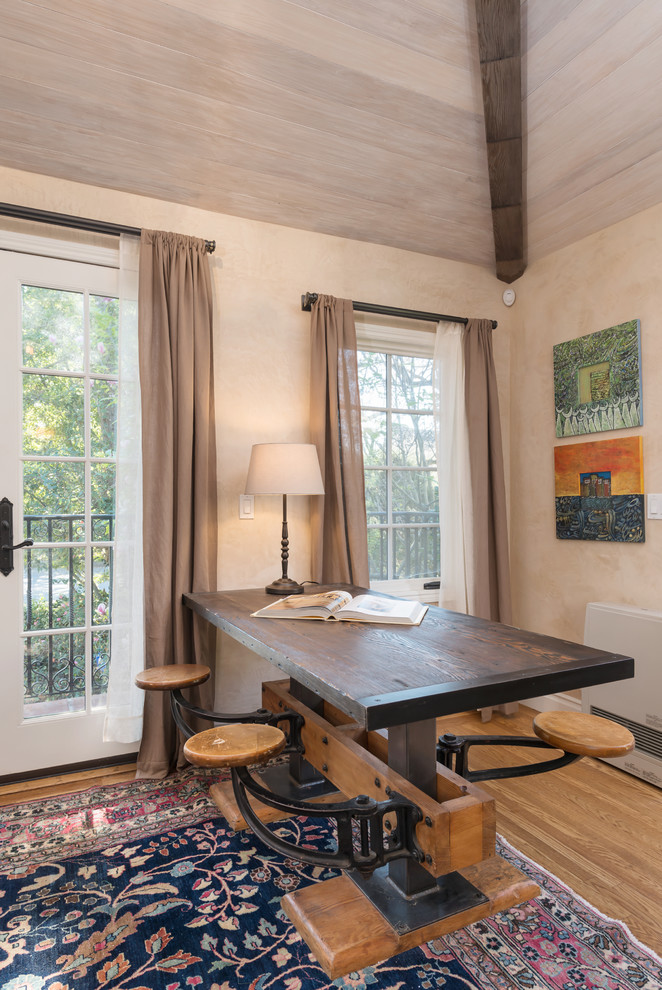 Imagen de sala de estar con biblioteca cerrada clásica pequeña con paredes beige y suelo de madera clara