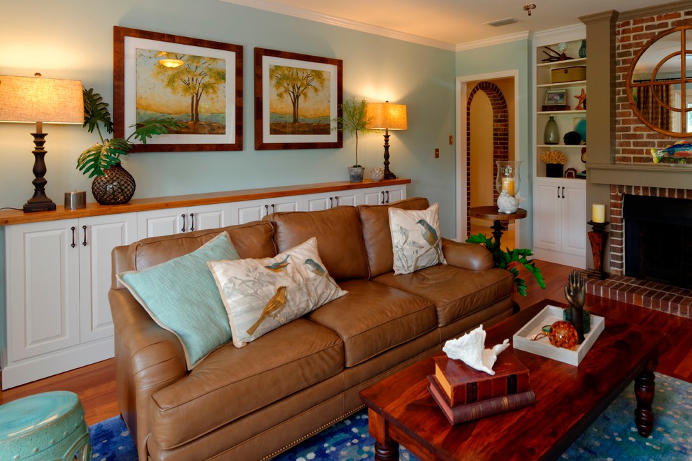 Foto de sala de estar cerrada clásica renovada de tamaño medio con paredes azules, suelo de madera en tonos medios, todas las chimeneas, marco de chimenea de madera y televisor colgado en la pared