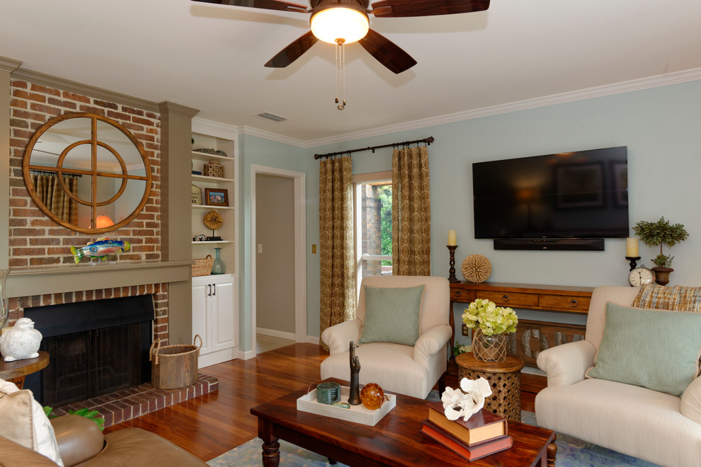 Mittelgroßes, Abgetrenntes Maritimes Wohnzimmer mit blauer Wandfarbe, TV-Wand, braunem Holzboden, Kamin und Kaminumrandung aus Holz in Tampa