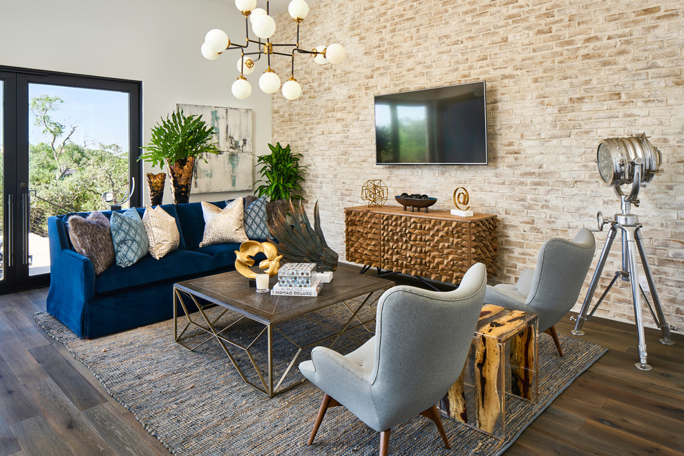 Modelo de sala de estar mediterránea sin chimenea con paredes blancas, suelo de madera oscura y televisor colgado en la pared