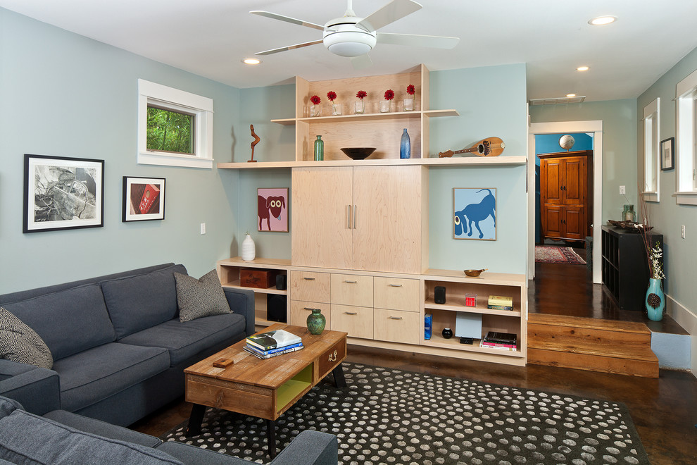 Modelo de sala de estar abierta contemporánea pequeña con paredes azules, suelo de cemento y pared multimedia