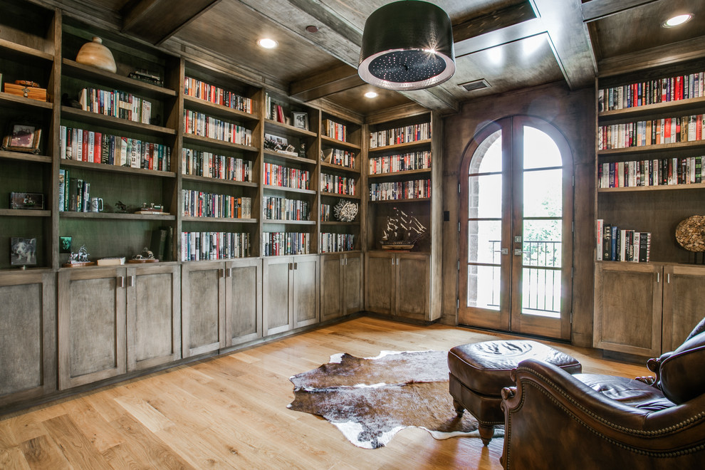 Immagine di un soggiorno chic chiuso con libreria e pavimento in legno massello medio
