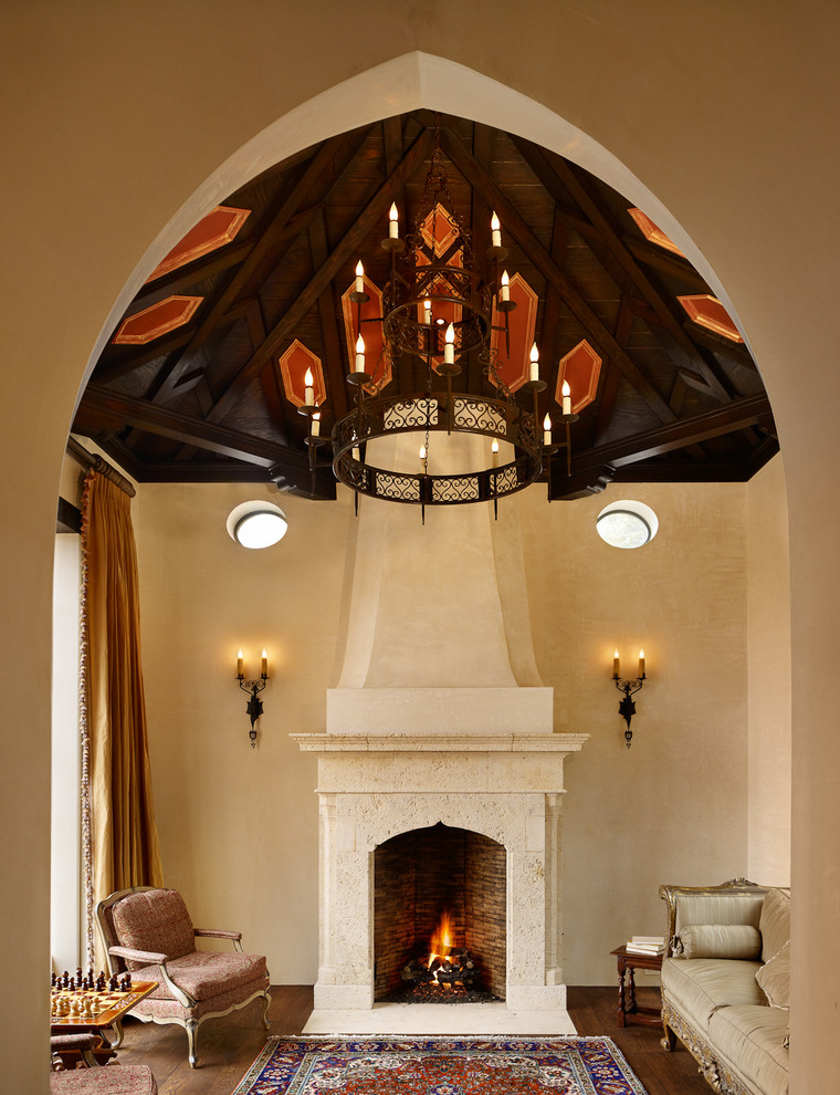 Design ideas for a medium sized mediterranean enclosed games room in Austin with beige walls, dark hardwood flooring, a standard fireplace, a stone fireplace surround and no tv.