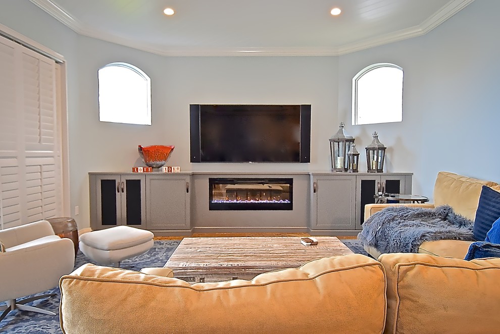 Imagen de sala de estar abierta clásica renovada de tamaño medio con paredes azules, suelo de mármol, chimenea lineal, marco de chimenea de madera y televisor colgado en la pared