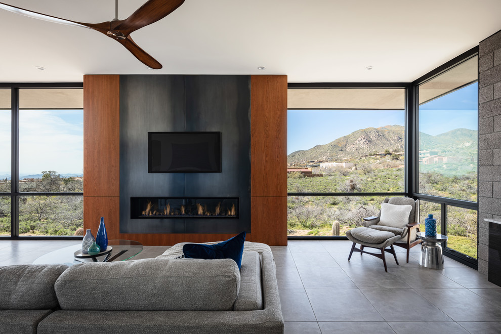 Пример оригинального дизайна: открытая гостиная комната в современном стиле с коричневыми стенами, полом из керамогранита, горизонтальным камином, фасадом камина из металла, телевизором на стене и серым полом