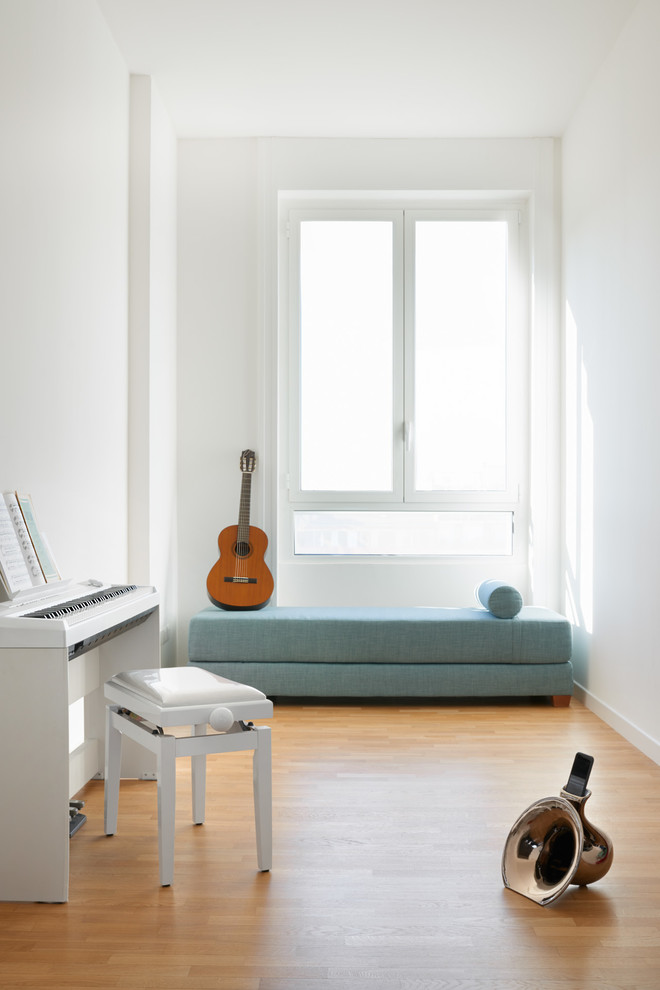 Immagine di un soggiorno moderno chiuso con sala della musica, pareti bianche e pavimento in legno massello medio