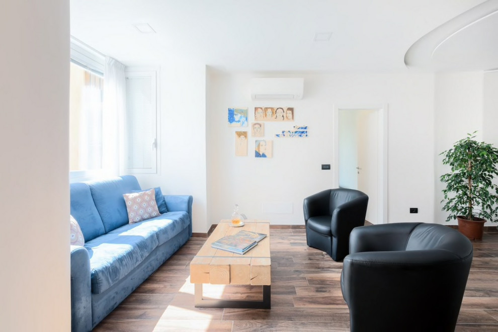 Imagen de sala de estar abierta contemporánea grande sin chimenea con paredes blancas, suelo de madera oscura y suelo marrón