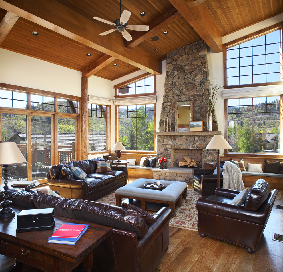 Inspiration for a large rustic open plan games room in Portland with a standard fireplace, a stone fireplace surround, beige walls, medium hardwood flooring and brown floors.