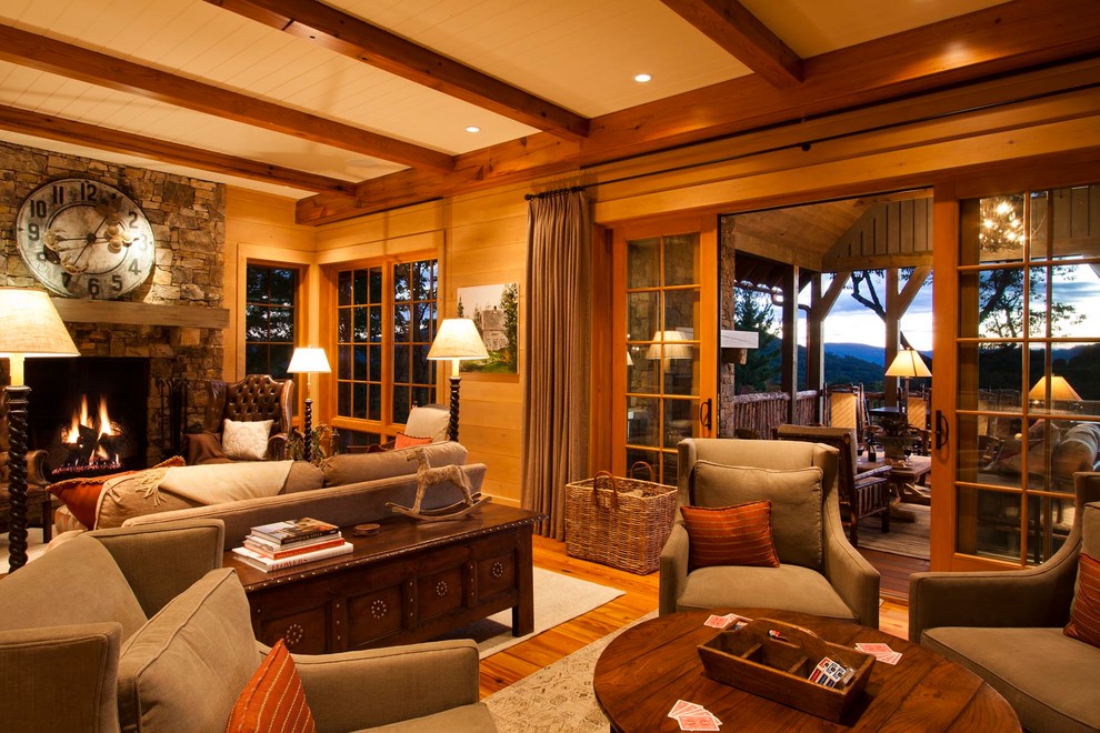 Example of a mountain style medium tone wood floor family room design in Other with beige walls, a standard fireplace, a stone fireplace and no tv