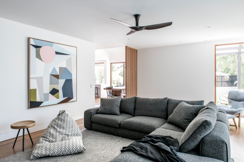 Offenes Modernes Wohnzimmer mit weißer Wandfarbe, braunem Holzboden und braunem Boden in Sunshine Coast