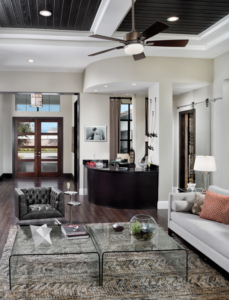 Geräumiges, Offenes Klassisches Wohnzimmer mit weißer Wandfarbe, braunem Holzboden und TV-Wand in Tampa