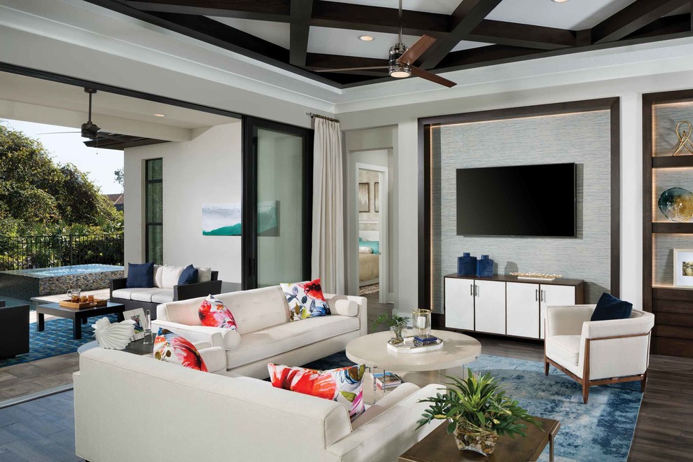 Идея дизайна: открытая гостиная комната в стиле неоклассика (современная классика) с серыми стенами, темным паркетным полом, телевизором на стене и коричневым полом