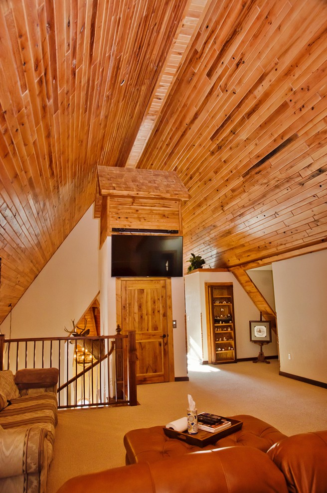 Cette photo montre une salle de séjour montagne de taille moyenne et ouverte avec un mur beige, moquette, aucune cheminée, un téléviseur fixé au mur, une bibliothèque ou un coin lecture et un sol beige.