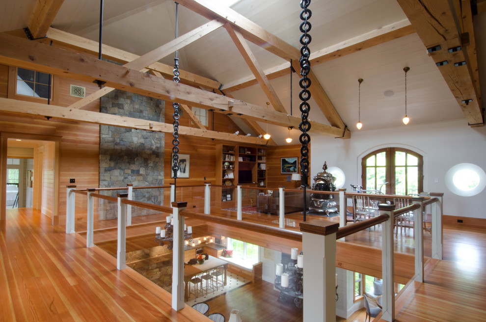 Diseño de sala de estar rural con paredes blancas, suelo de madera en tonos medios y suelo marrón