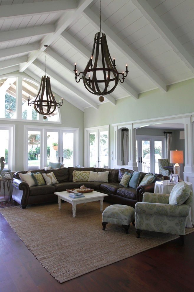 Diseño de sala de estar abierta marinera grande con paredes verdes, suelo de madera en tonos medios y suelo marrón