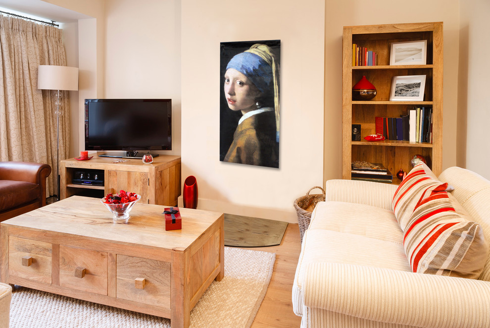 Imagen de sala de estar cerrada tradicional de tamaño medio sin chimenea con paredes beige, suelo de madera clara y televisor independiente