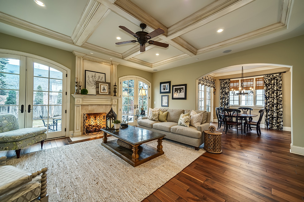 This is an example of a large classic games room in Chicago with beige walls, dark hardwood flooring, a standard fireplace, a stone fireplace surround, a wall mounted tv and brown floors.