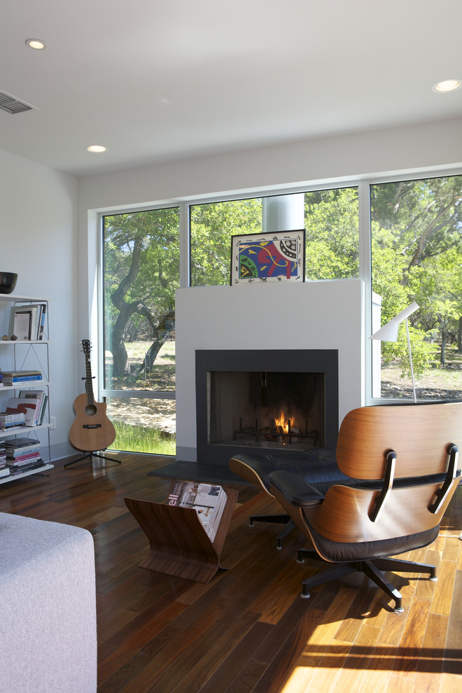 Minimalist dark wood floor and brown floor family room photo in Austin with white walls and a standard fireplace