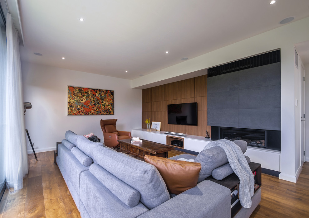 Photo of a medium sized contemporary open plan games room in Melbourne with white walls, marble flooring, a standard fireplace, a stone fireplace surround, a wall mounted tv and brown floors.