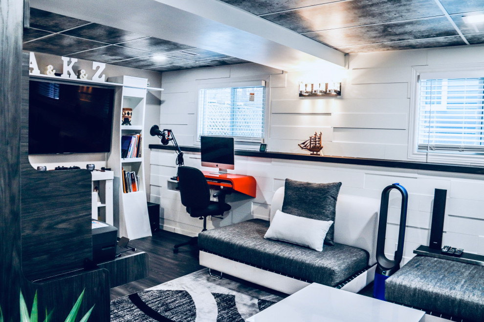 На фото: изолированная гостиная комната среднего размера в стиле модернизм с музыкальной комнатой, белыми стенами, полом из винила, телевизором на стене и серым полом с