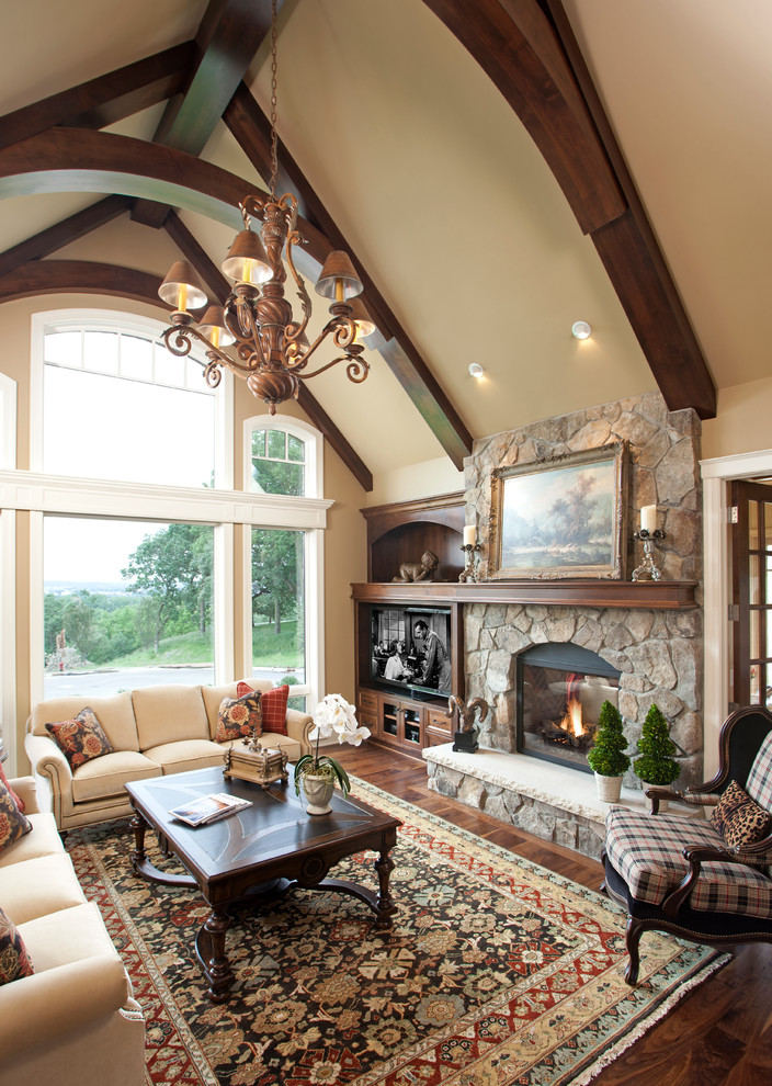 Inspiration for an expansive traditional open plan games room in Minneapolis with beige walls, dark hardwood flooring, a two-sided fireplace, a stone fireplace surround and a freestanding tv.