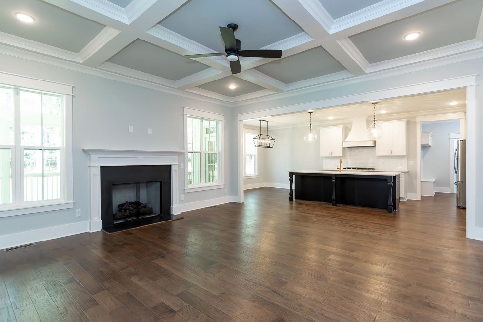 Example of a large classic open concept medium tone wood floor and brown floor family room design in Raleigh with a music area, gray walls, a standard fireplace, a stone fireplace and a wall-mounted tv