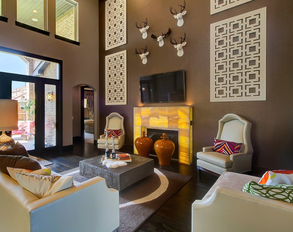 Стильный дизайн: гостиная комната в стиле фьюжн с коричневыми стенами, темным паркетным полом, стандартным камином и телевизором на стене - последний тренд
