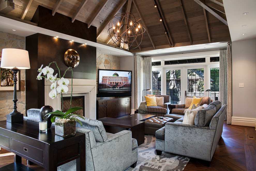 Imagen de sala de estar tradicional renovada con paredes grises, suelo de madera oscura, todas las chimeneas y televisor independiente