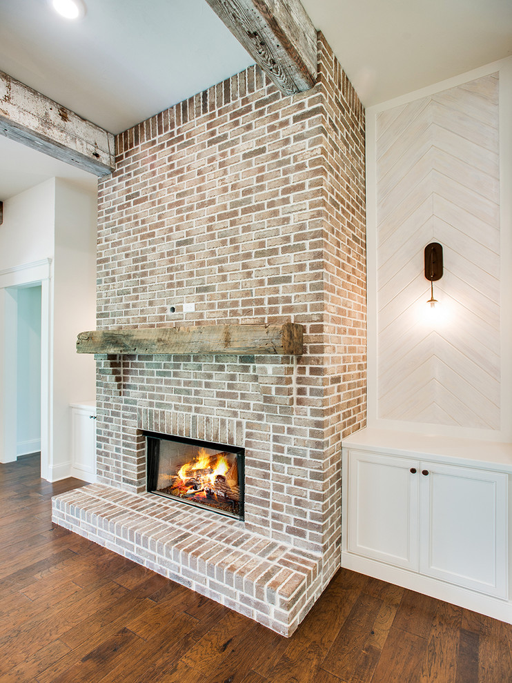 Стильный дизайн: гостиная комната в стиле кантри с белыми стенами, стандартным камином и фасадом камина из кирпича - последний тренд