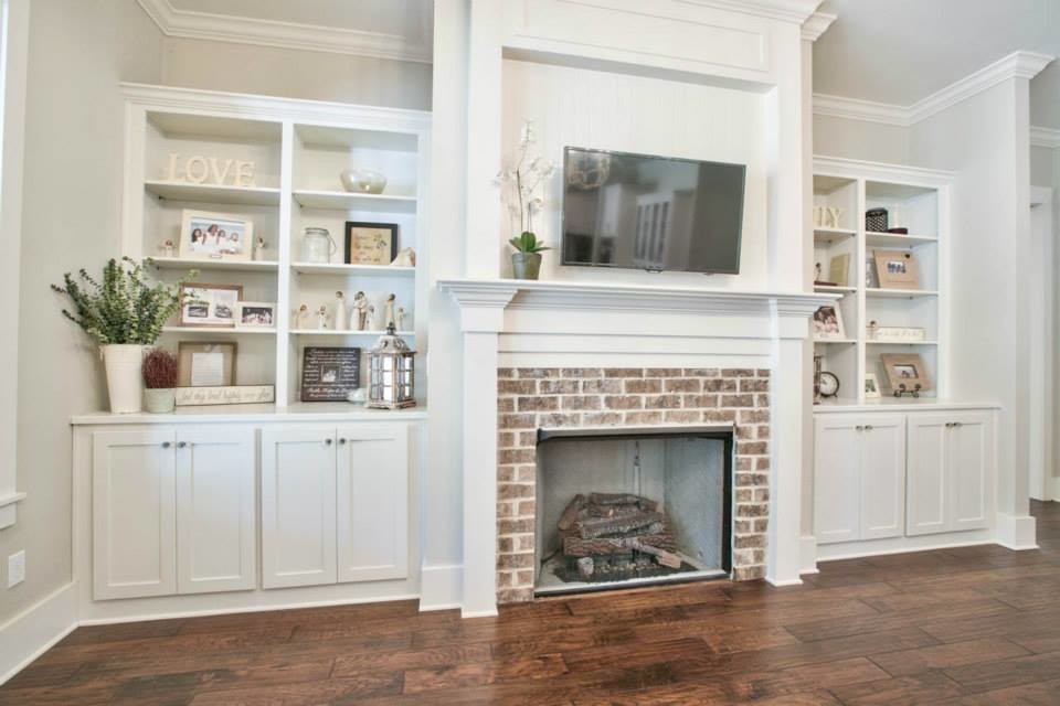 Family room - large coastal open concept medium tone wood floor family room idea in Atlanta with white walls, a standard fireplace, a brick fireplace and a wall-mounted tv