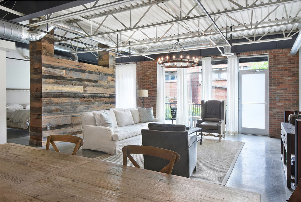 Ejemplo de sala de estar tipo loft industrial pequeña con paredes blancas, suelo de cemento, suelo gris y alfombra
