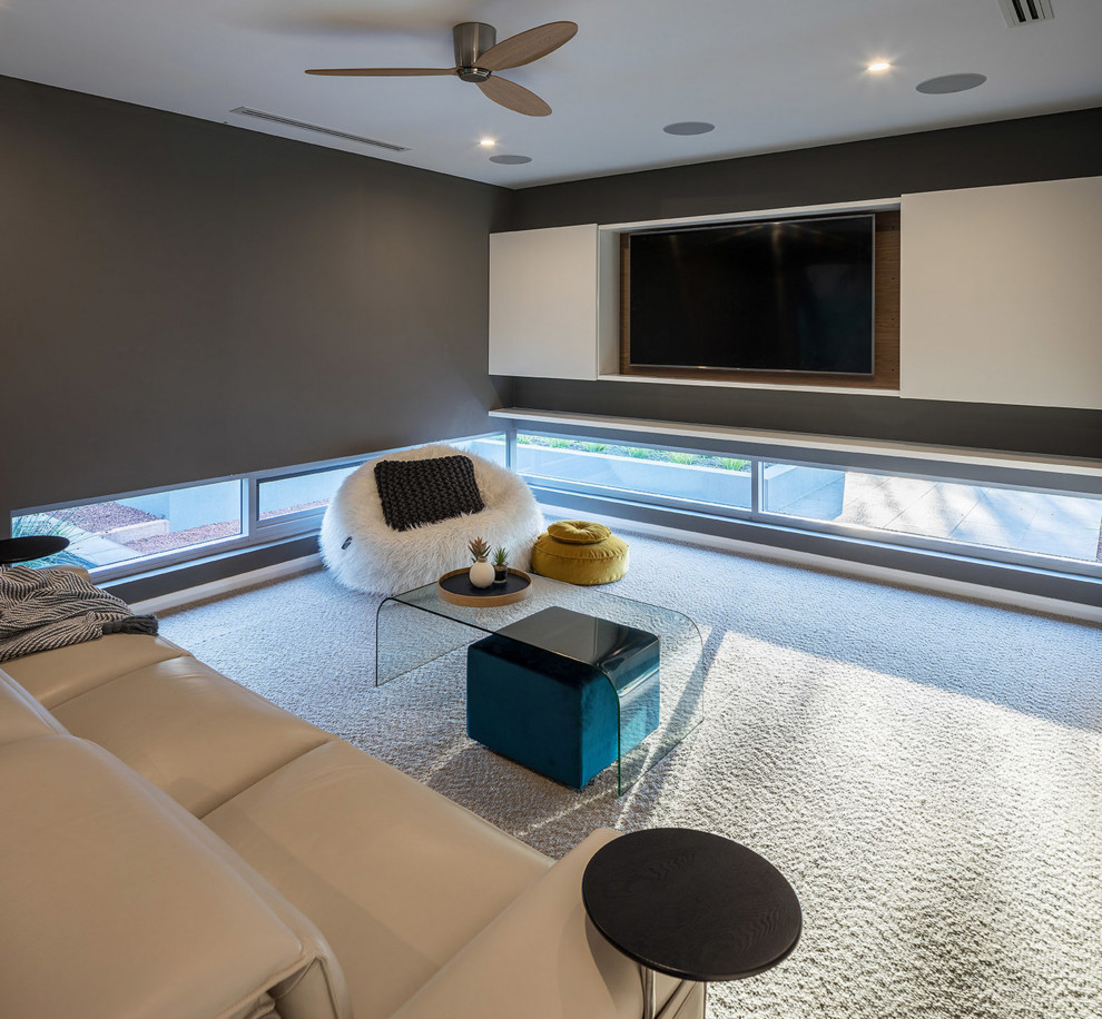 На фото: изолированная гостиная комната среднего размера в современном стиле с серыми стенами, ковровым покрытием, скрытым телевизором и бежевым полом без камина с