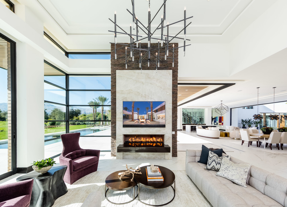 Contemporary open plan games room in Orange County with white walls, a ribbon fireplace, a stone fireplace surround and white floors.