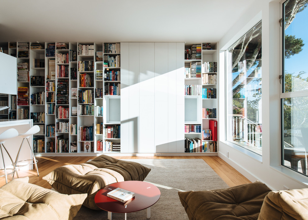Inspiration pour une salle de séjour design avec un téléviseur dissimulé et une bibliothèque ou un coin lecture.
