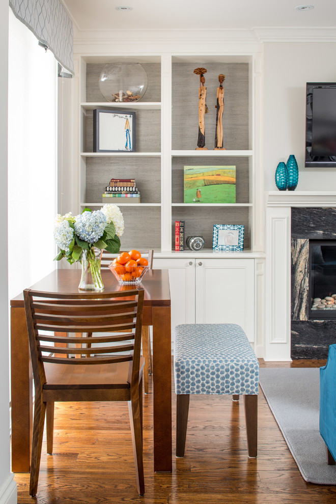 Medium sized traditional open plan dining room in Toronto with white walls, medium hardwood flooring, a standard fireplace and a stone fireplace surround.