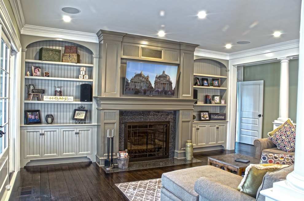 Mittelgroßes, Offenes Klassisches Wohnzimmer mit grüner Wandfarbe, dunklem Holzboden, Kamin, Kaminumrandung aus Stein und TV-Wand in New York