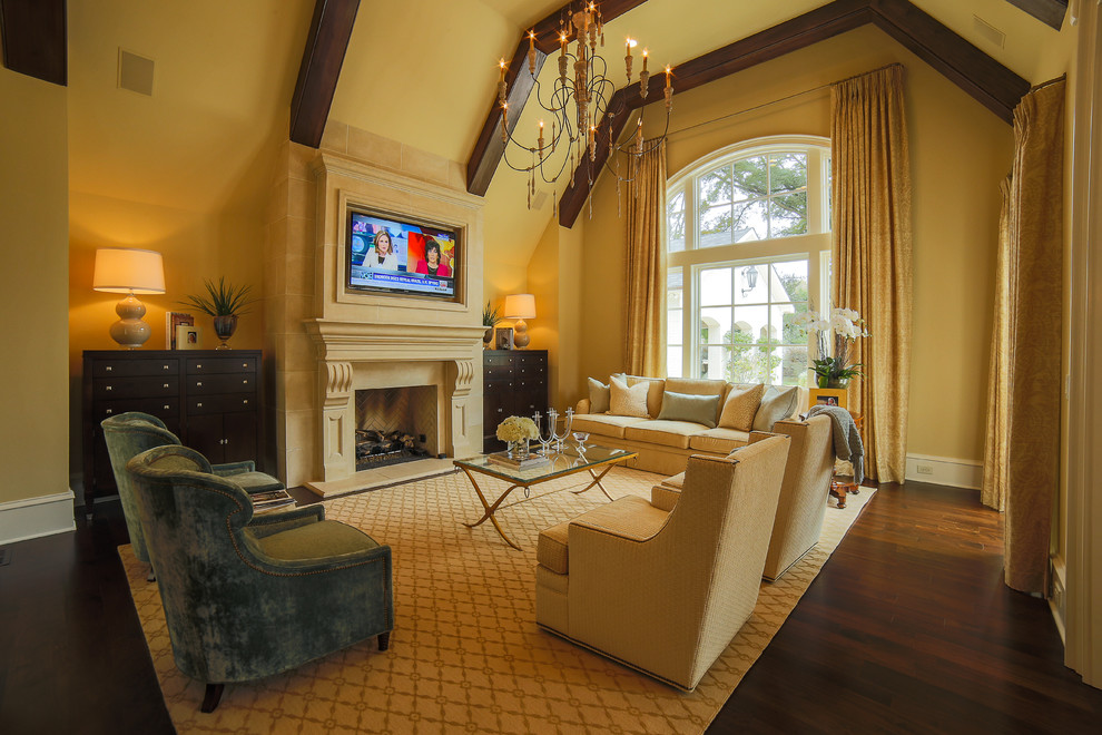 Immagine di un grande soggiorno chic aperto con pareti beige, parquet scuro e TV a parete